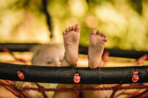 Kinderfüße ohne Socken auf Schaukel