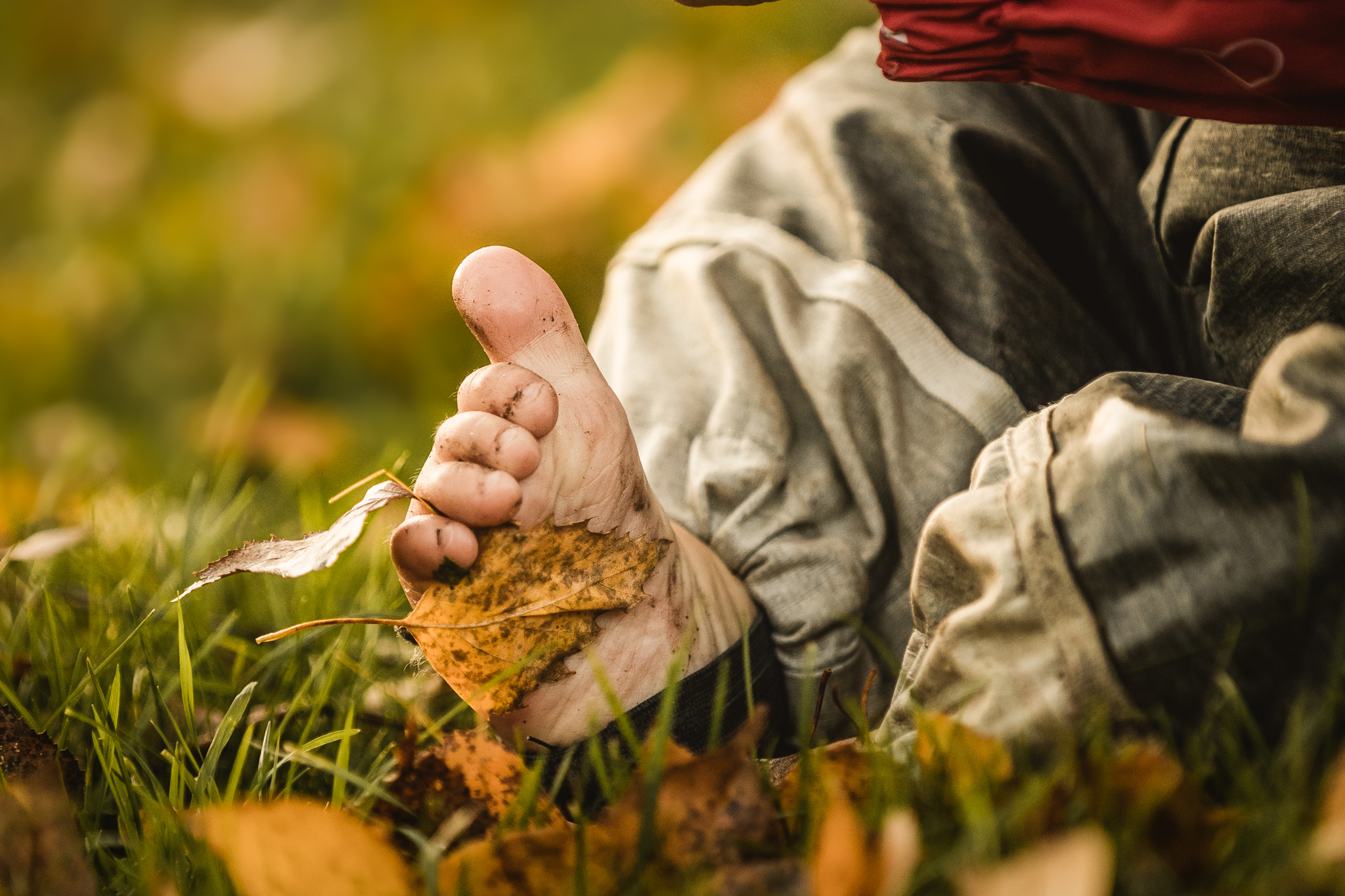 Kind barfuß auf einer Wiese im Herbst